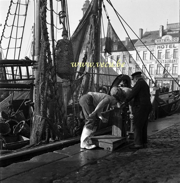 photo ancienne  de bateaux de pêche  Pêcheurs étalonnant la balance. A l'arrière plan l'hôtel Waterloo av Vindictive