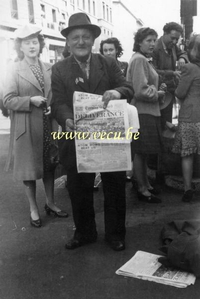 foto van  Krantverkoper met de voorpagina van de Evening Standard van 15-08-1945 - Deliverance