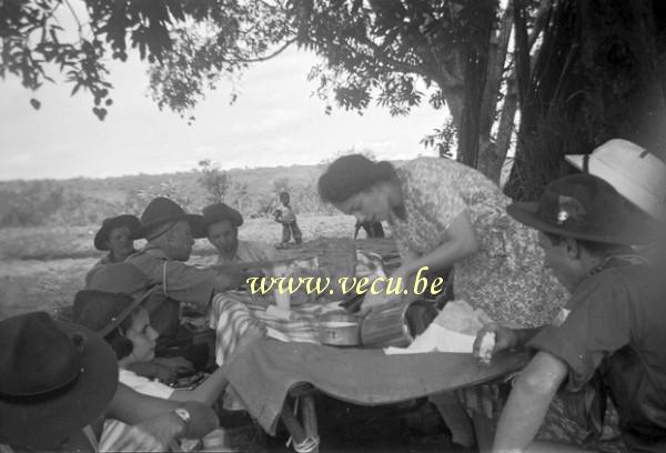 photo ancienne  Pique-nique scout sous le regard d'un petit garçon africain