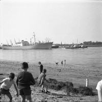  Enfants en plein jeu lors du passage du cargo Seatle tiré par 2 remorqueurs