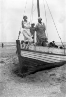  La famille s'amuse sur le bateau ensablé sur la plage