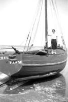 De Panne&nbsp;Een vrouw poseert aan boord van een traditionele vissersboot op het strand