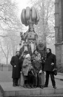 Binche Petite pose devant la statue d'un Gilles sculptée par Robert Delnest