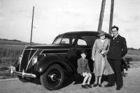 België&nbsp;Een gezin poseert trots op een kasseiweg naast hun Belgische Ford V8 personenauto, aan het einde van de jaren 30.
